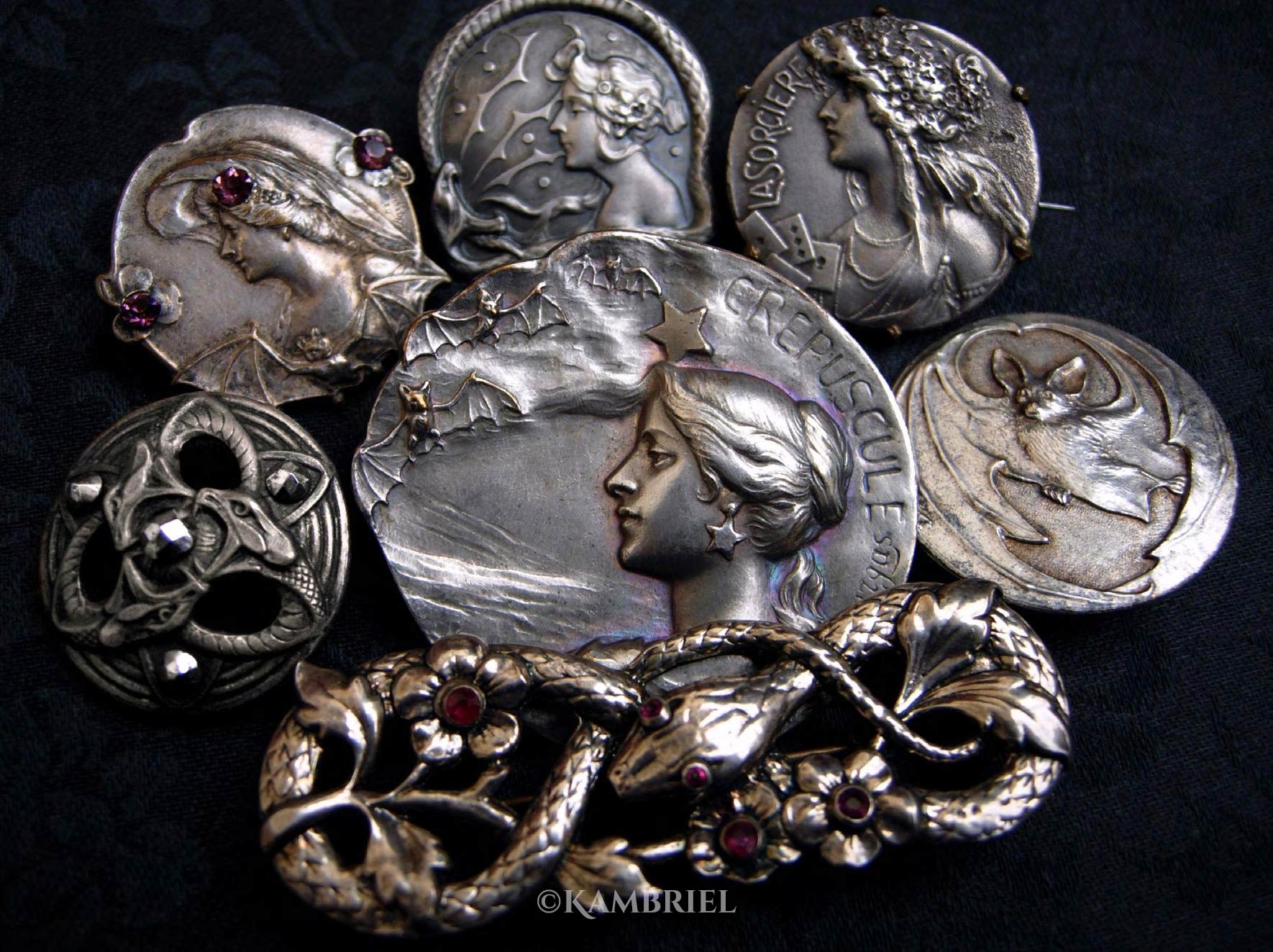 Serpents and Sorceresses—a decadent assortment of antique Art Nouveau brooches and buttons, including interlaced serpents accented with shimmering garnets and marcasite, a fluttering of bats, plus the witchy women who are perfectly content to share their time with either (and perhaps be convinced to tell your fortune while doing so).