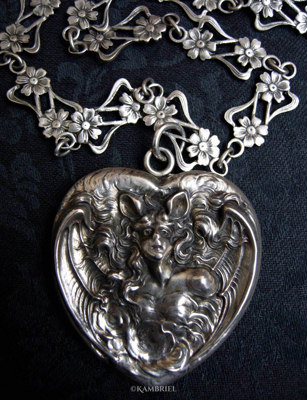Bat Woman heart-shaped photo locket made by Unger Brothers, paired with a handmade antique silver French Art Nouveau sautoir chain with floral filigree design, circa 1900.